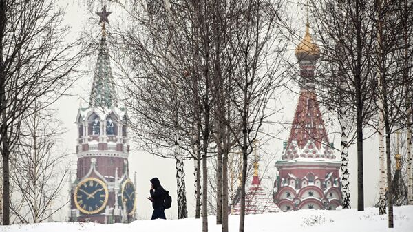Homem passa á frente da torre Spasskaya do Kremlin e a Catedral de São Basílio em Moscou, Rússia, 3 de fevereiro de 2022 - Sputnik Brasil