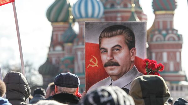 Apoiadores do partido comunista seguram um retrato de Josef Stalin enquanto caminham para colocar flores em seu túmulo para marcar o 68º aniversário de sua morte na Praça Vermelha em Moscou, em 5 de março de 2021 - Sputnik Brasil