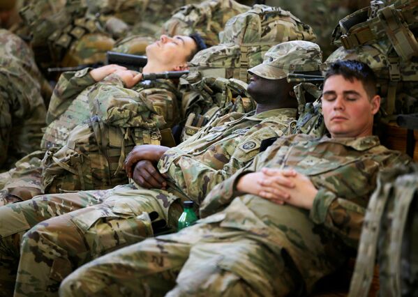 Soldados da 82ª Divisão Aerotransportada do Exército dos EUA descansam enquanto esperam para embarcar em um avião de transporte com destino à Europa, em Fort Bragg, Carolina do Norte, EUA, 14 de fevereiro de 2022. - Sputnik Brasil
