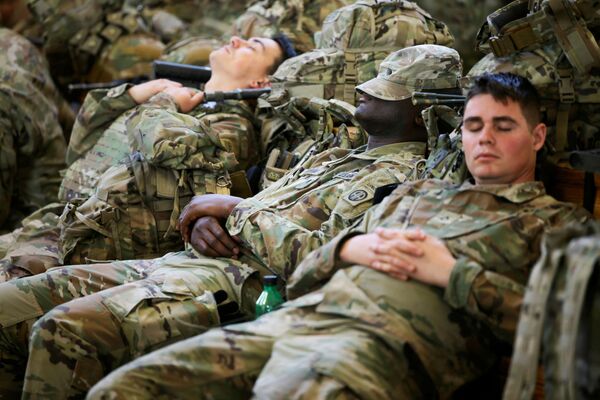 Soldados da 82ª Divisão Aerotransportada do Exército dos EUA descansam enquanto esperam para embarcar em um avião de transporte com destino à Europa, em Fort Bragg, Carolina do Norte, EUA, 14 de fevereiro de 2022. - Sputnik Brasil