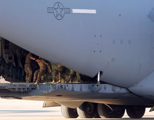 Soldados do Exército dos EUA carregam aeronave C-17 da Força Aérea dos EUA perto de onde os paraquedistas da 82ª Divisão Aerotransportada embarcaram em um avião de transporte com destino à Europa, em Fort Bragg, Carolina do Norte, EUA, 14 de fevereiro de 2022. - Sputnik Brasil