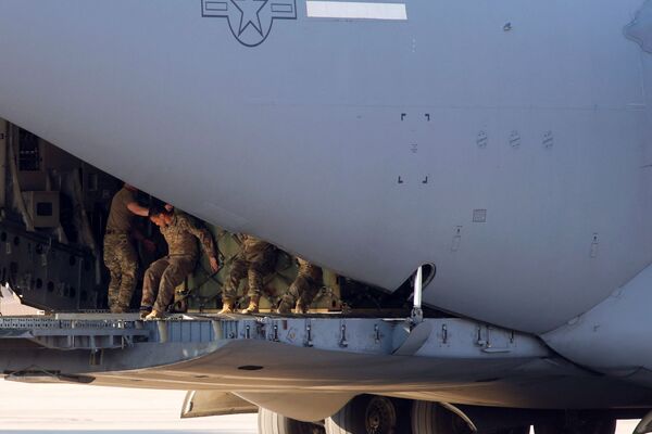 Soldados do Exército dos EUA carregam aeronave C-17 da Força Aérea dos EUA perto de onde os paraquedistas da 82ª Divisão Aerotransportada embarcaram em um avião de transporte com destino à Europa, em Fort Bragg, Carolina do Norte, EUA, 14 de fevereiro de 2022. - Sputnik Brasil