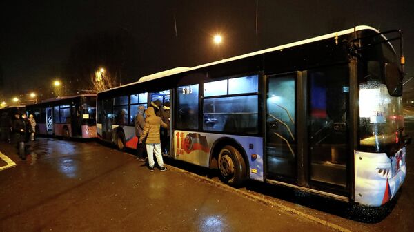 Pessoas embarcam em ônibus organizados para evacuar moradores locais, na cidade de Donetsk, Ucrânia, 18 de fevereiro de 2022 - Sputnik Brasil