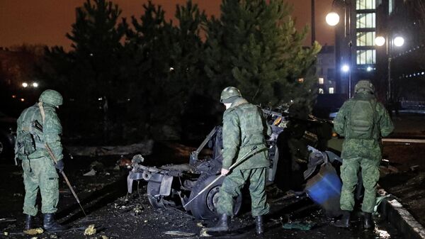 Na autoproclamada República Popular de Donetsk, especialistas inspecionam um carro que, segundo autoridades locais, foi explodido perto de um prédio do governo, em 18 de fevereiro de 2022 - Sputnik Brasil