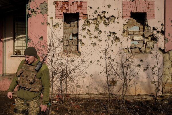 Soldado ucraniano passa por parede crivada de balas na autoproclamada República Popular de Lugansk, 19 de fevereiro de 2022 - Sputnik Brasil