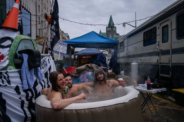 Manifestantes em banheira quente durante protesto de caminhoneiros contra restrições de saúde do governo fora do Parlamento canadense em Ottawa, Canadá, 16 de fevereiro de 2022 - Sputnik Brasil