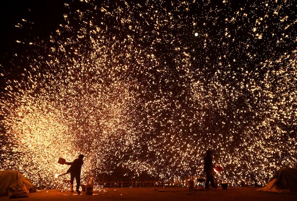Ferreiros jogam metal fundido para criar chuva de faíscas na véspera do Festival das Lanternas, no final das celebrações do Ano Novo Lunar, Pequim, China, 15 de fevereiro de 2022 - Sputnik Brasil