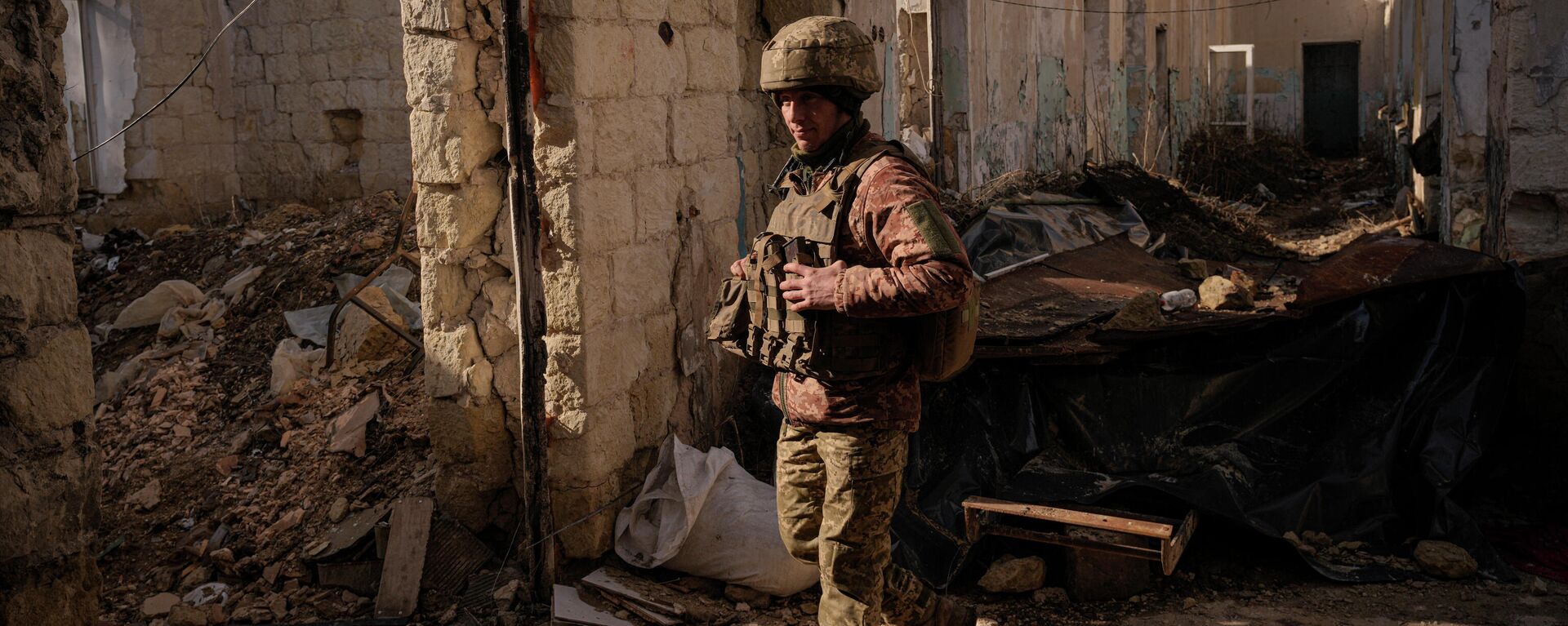 Um soldado ucraniano entra em uma casa destruída perto da vila de Krymske, na na autoproclamada República Popular de Lugansk (RPL), em 19 de fevereiro de 2022 - Sputnik Brasil, 1920, 20.02.2022