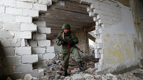 Soldado da autoproclamada República Popular de Lugansk patrulha o prédio danificado de uma escola em 17 de fevereiro de 2022 - Sputnik Brasil