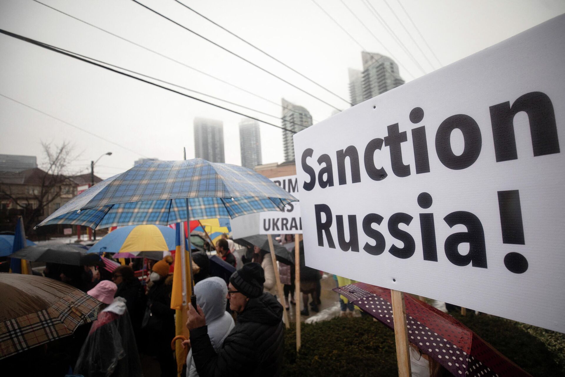 Manifestante segura cartaz que diz Sanções contra Rússia durante ato ao lado do Consultado ucraniano em Toronto, Canadá, 22 de fevereiro de 2022 - Sputnik Brasil, 1920, 23.02.2022