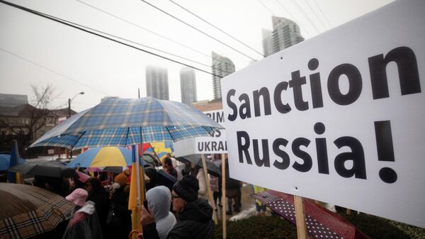 Manifestante segura cartaz que diz Sancione a Rússia! durante ato ao lado do Consulado ucraniano em Toronto, Canadá, 22 de fevereiro de 2022. - Sputnik Brasil