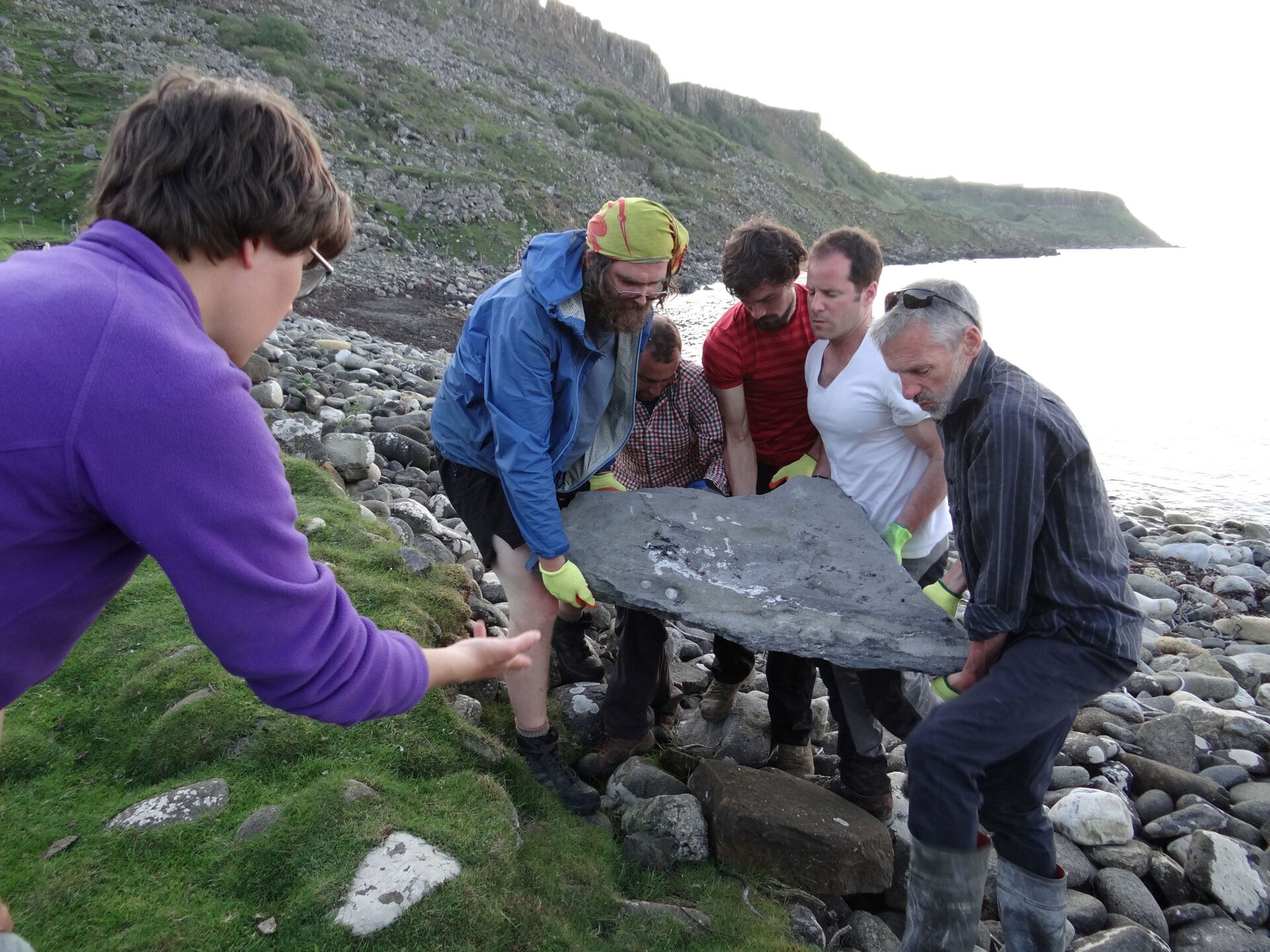 Pesquisadores carregam parte do fóssil de um réptil voador do período Jurássico recém-identificado, o pterossauro chamado Dearc sgiathanach foi encontrado em uma praia rochosa na Ilha de Skye, na Escócia, maio de 2017 - Sputnik Brasil, 1920, 23.02.2022