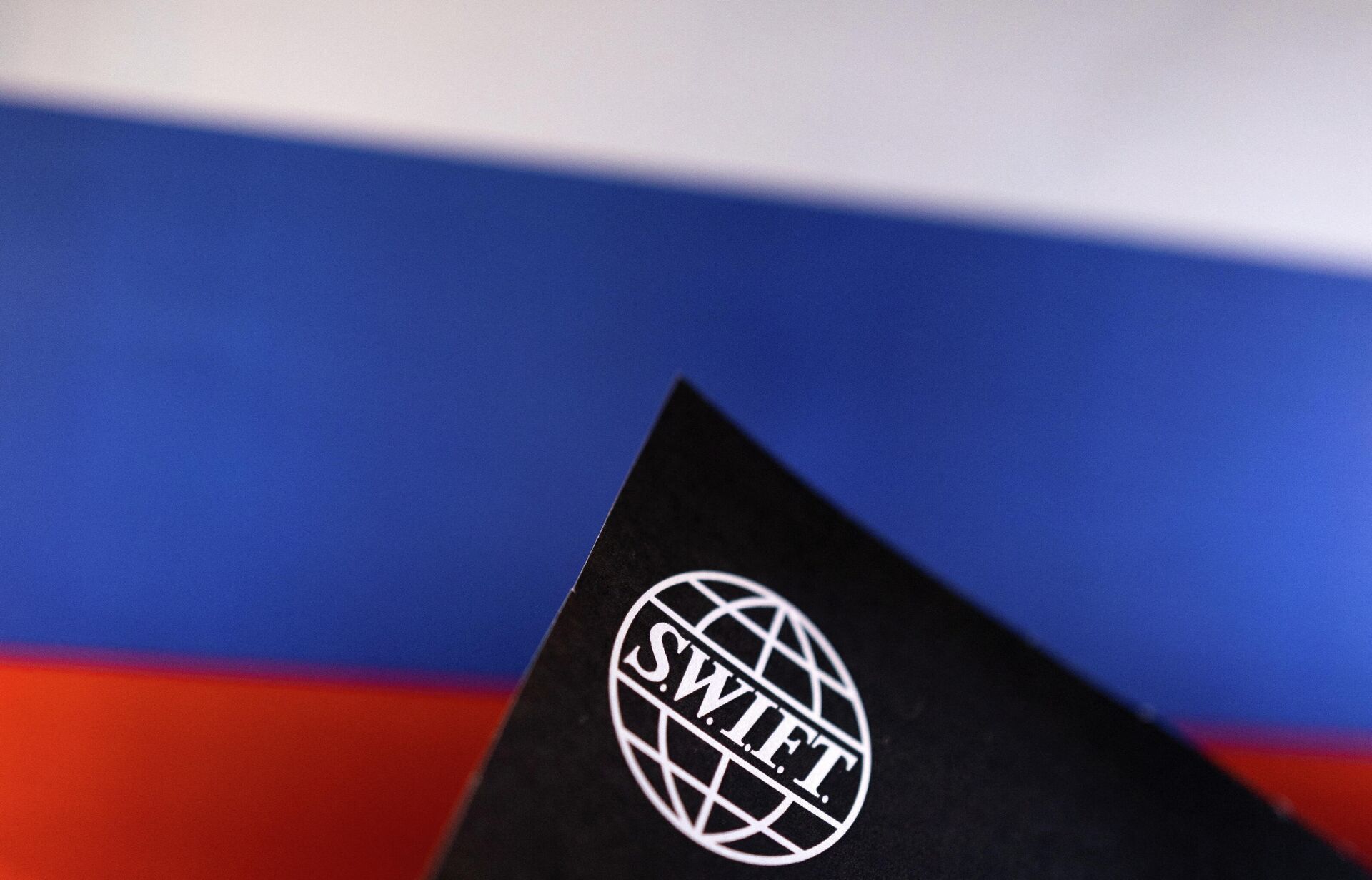 A logo da Sociedade Mundial de Telecomunicações Financeiras Interbancárias (SWIFT) com as cores da bandeira russa ao fundo - Sputnik Brasil, 1920, 03.03.2022
