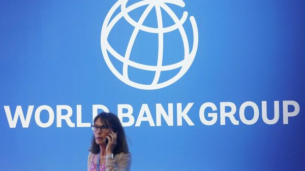 Na Indonésia, uma participante do encontro anual do Banco Mundial aparece diante do logo do grupo, em 12 de outubro de 2018 - Sputnik Brasil