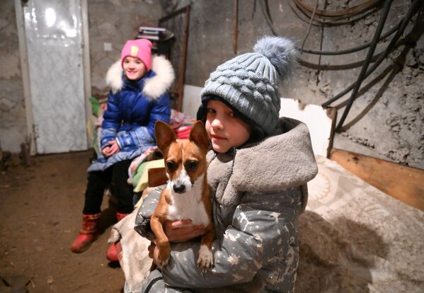 Crianças se escondem com cachorro em porão de uma casa dos disparos das Forças Armadas da Ucrânia em Gorlovka - Sputnik Brasil