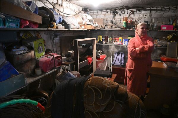 Mulher se esconde em porão de uma casa dos disparos das Forças Armadas da Ucrânia em Gorlovka - Sputnik Brasil