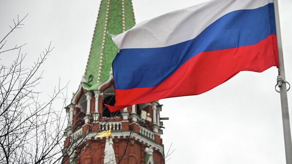 Uma bandeira russa acena ao lado de uma das torres do Kremlin no centro de Moscou em 26 de fevereiro de 2022 - Sputnik Brasil