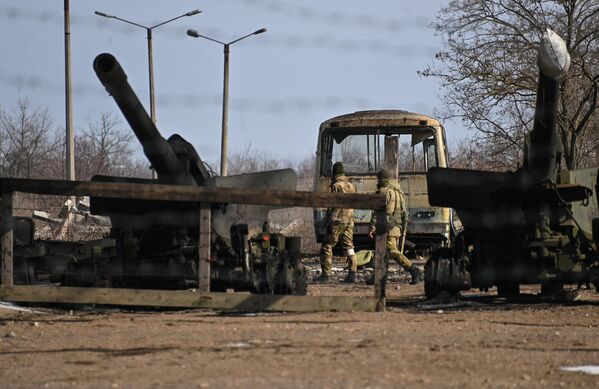 Militares junto de obuseiros de unidade de artilharia abandonada pelas Forças Armadas da Ucrânia em depósito de metais de Berdyansk - Sputnik Brasil