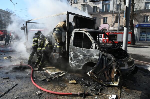 Equipe de bombeiros vistoria caminhão atingido pela explosão causada por um míssil Tochka-U lançado pela Ucrânia contra Donetsk. - Sputnik Brasil