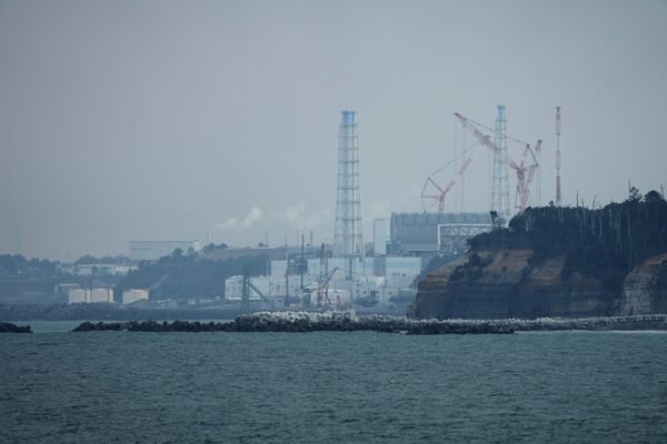 A usina nuclear de Fukushima Daiichi fica nas cidades costeiras de Okuma e Futaba, vista do porto de pesca de Ukedo na cidade de Namie, nordeste do Japão, quarta-feira, 2 de março de 2022 - Sputnik Brasil