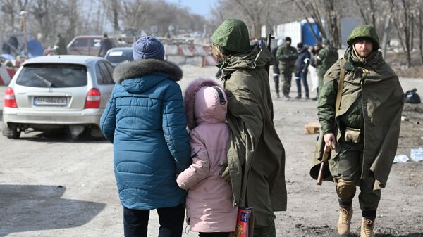 Militar da Milícia Popular de Donetsk fala com refugiados na saída da cidade de Mariupol 
 - Sputnik Brasil