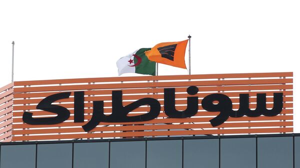 Bandeira da petrolífera Sonatrach ao lado da bandeira da Argélia na sede em Argel, 8 de fevereiro de 2018 - Sputnik Brasil