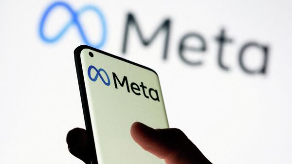 Mulher segura smartphone com logotipo da Meta diante de um fundo com outro logotipo da empresa em 28 de outubro de 2021 - Sputnik Brasil