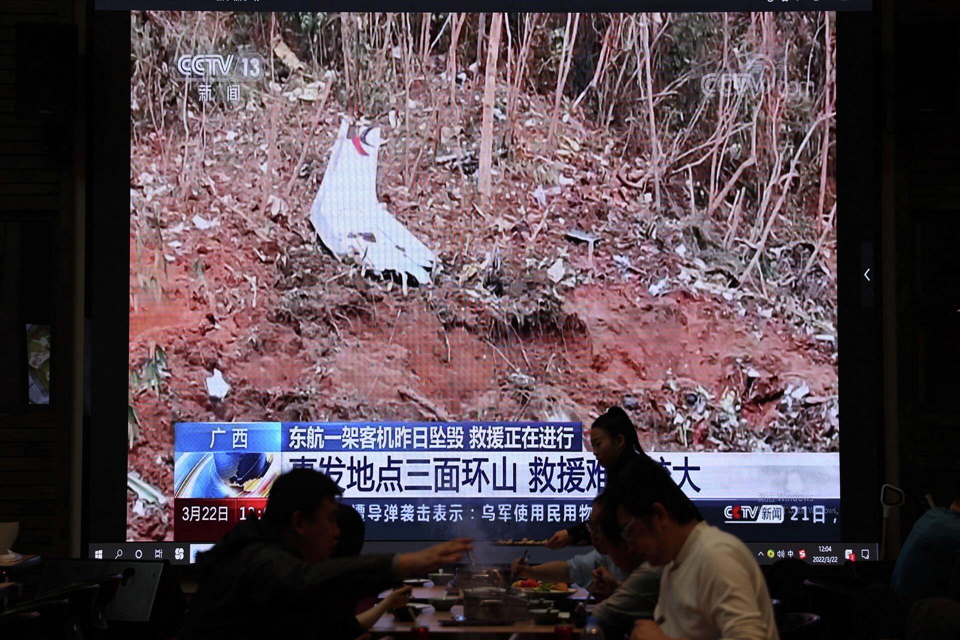 Vista do local com destroços do Boeing que caiu no leste da China, na reportagem na televisão em um dos restaurantes em Pequim, 22 de março de 2022 - Sputnik Brasil, 1920, 22.03.2022