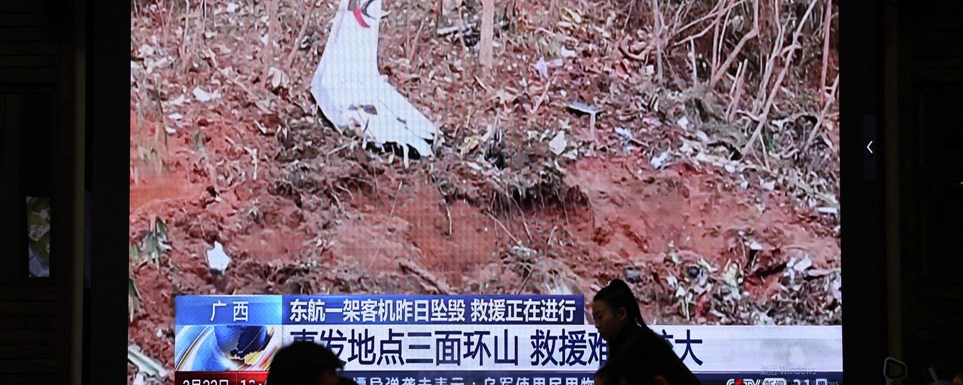 Vista do local com destroços do Boeing que caiu no leste da China, na reportagem na televisão em um dos restaurantes em Pequim, 22 de março de 2022 - Sputnik Brasil, 1920, 22.03.2022