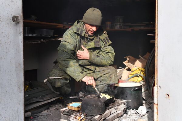 Combatente da Milícia Popular da República de Donetsk preparando refeição no Aeroporto de Mariupol libertado - Sputnik Brasil