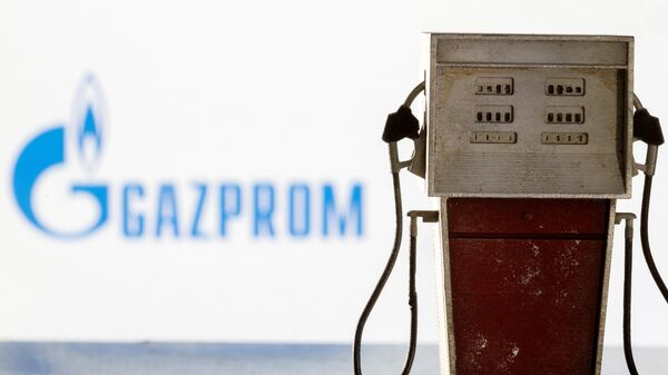 Modelo de bomba de gasolina em frente de logotipo da Gazprom em 25 de março de 2022 - Sputnik Brasil