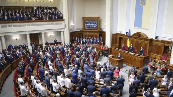 O novo presidente ucraniano Vladimir Zelensky, ao fundo à direita, canta o hino nacional durante sua cerimônia de posse na Suprema Rada, em Kiev, Ucrânia, 20 de maio de 2019 - Sputnik Brasil