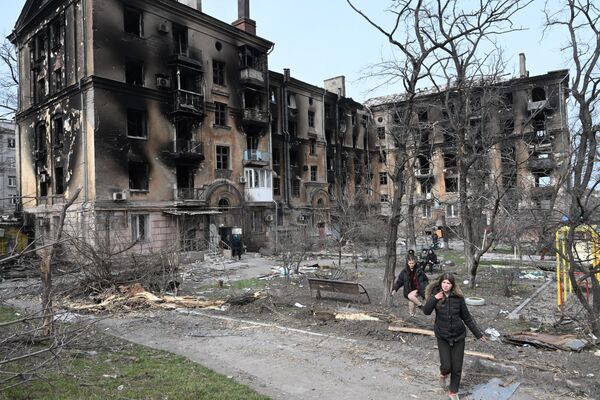 Moradores no pátio de prédio residencial destruído em Mariupol - Sputnik Brasil