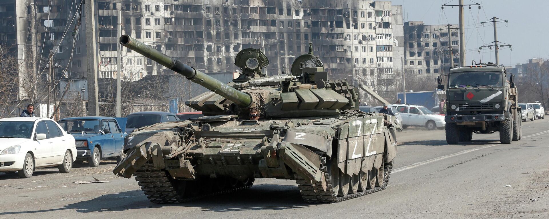 Um tanque e um caminhão militar de tropas pró-Rússia dirigem ao longo de uma estrada na cidade portuária de Mariupol, Ucrânia, em 5 de abril de 2022  - Sputnik Brasil, 1920, 05.04.2022