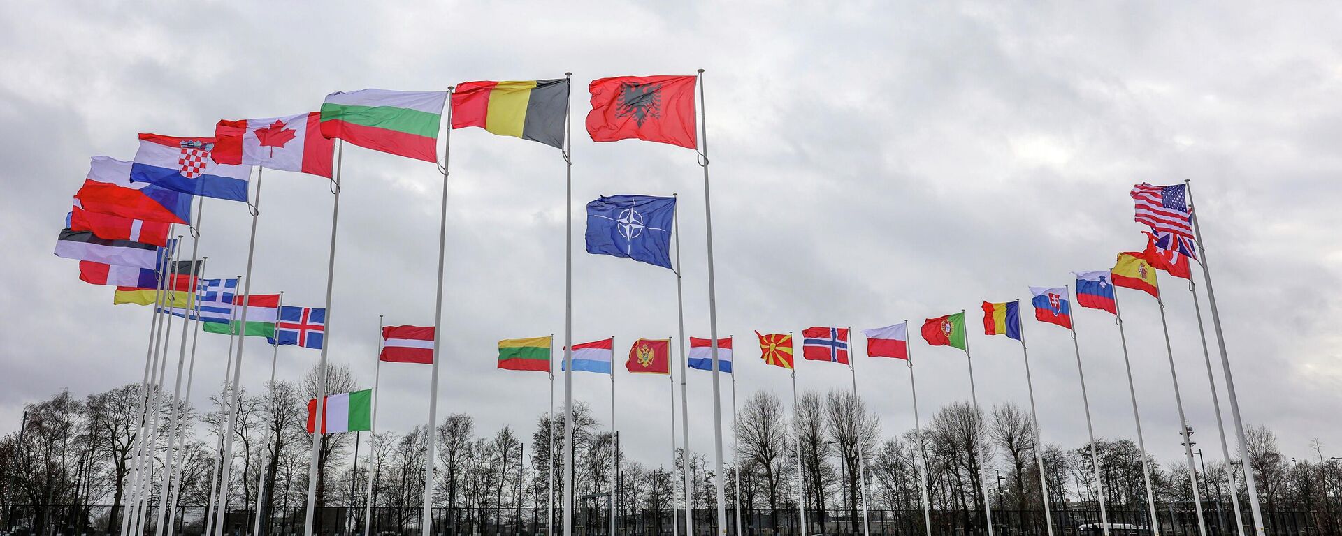Bandeiras dos países-membros da Organização do Tratado do Atlântico Norte (OTAN) tremulam ao vento do lado de fora da sede da aliança em Bruxelas, 22 de fevereiro de 2022 - Sputnik Brasil, 1920, 11.06.2022