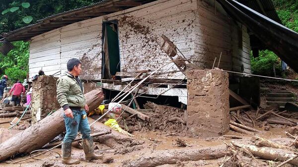Em Abriaqui, na Colômbia, um homem aparece ao lado de uma construção destruída por uma inundação em uma mina de ouro que deixou mortos, em 8 de abril de 2022 - Sputnik Brasil