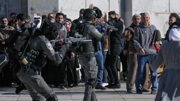 Forças de segurança israelenses apontam armas para palestinos no complexo da mesquita de Al-Aqsa, em Jerusalém, em 15 de abril de 2022 - Sputnik Brasil