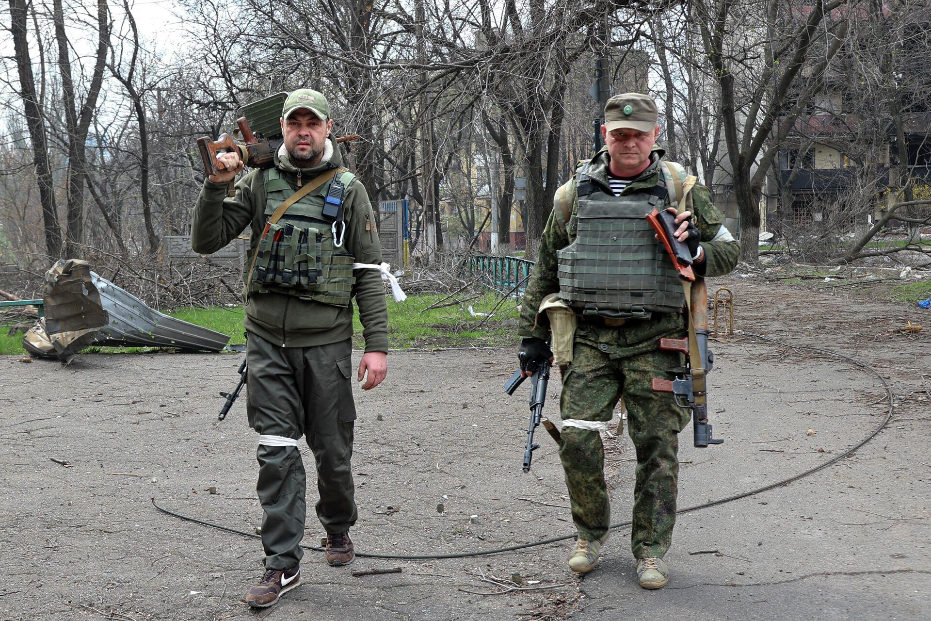 Militares armados da Milícia Popular de Donetsk olham para um fotógrafo enquanto carregam armas capturadas em uma área controlada por forças apoiadas pela Rússia em Mariupol, Ucrânia, 15 de abril de 2022 - Sputnik Brasil, 1920, 18.04.2022