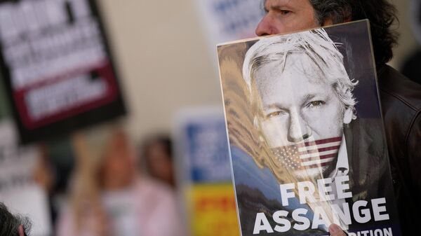 Apoiadores de Julian Assange seguram cartazes do ativista do WikiLeaks junto da Corte dos Magistrados de Westminster em Londres, Reino Unido, 20 de abril de 2022 - Sputnik Brasil