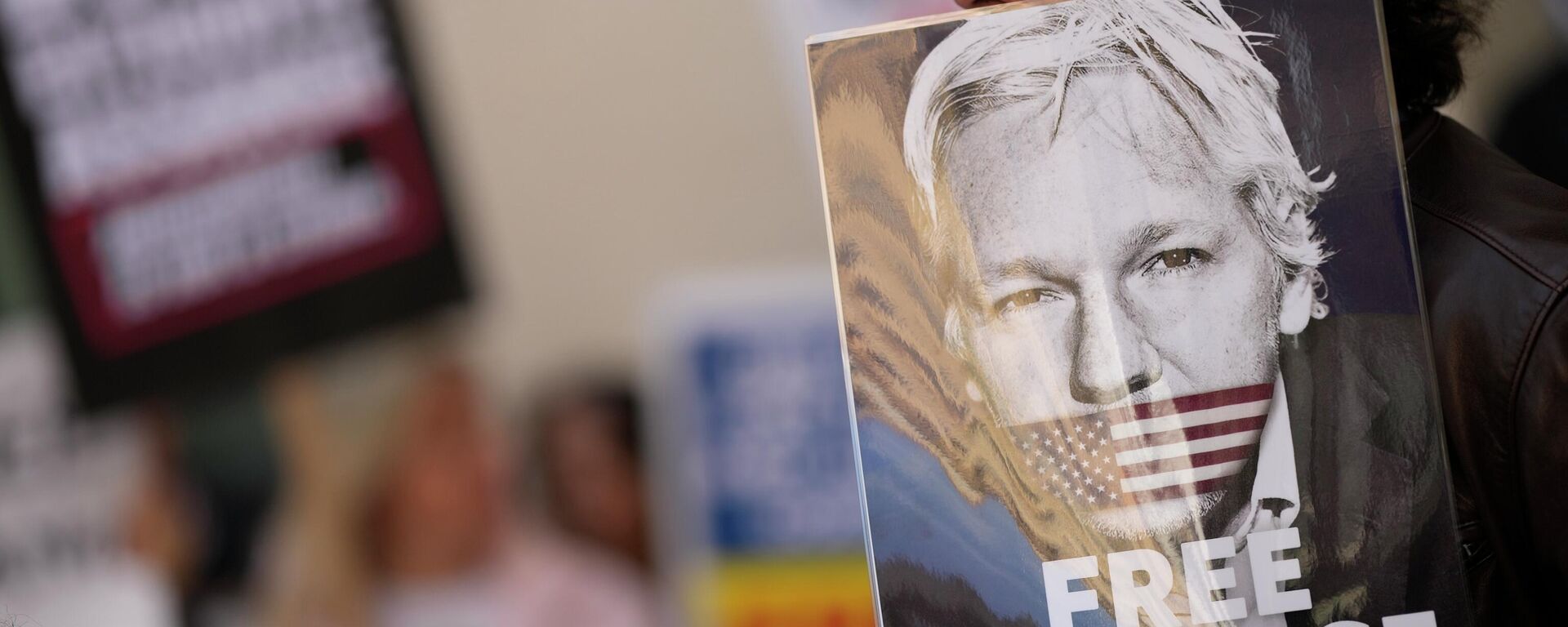 Apoiadores de Julian Assange seguram cartazes do ativista do WikiLeaks junto da Corte dos Magistrados de Westminster em Londres, Reino Unido, 20 de abril de 2022 - Sputnik Brasil, 1920, 17.06.2022