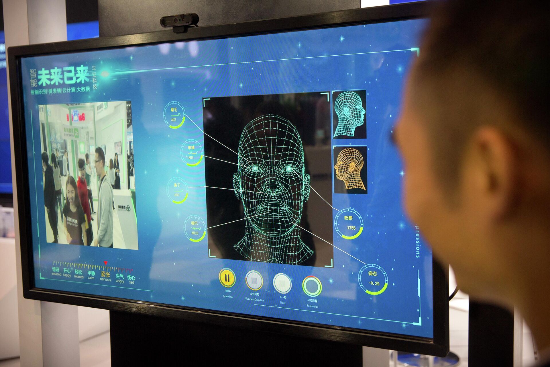 Homem observa um monitor de câmera de reconhecimento facial em um estande da empresa chinesa Ping'an Technology, em Pequim, em 25 de abril de 2018 - Sputnik Brasil, 1920, 22.08.2022