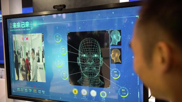 Homem observa um monitor de câmera de reconhecimento facial em um estande da empresa chinesa Ping'an Technology, em Pequim, 25 de abril de 2018. - Sputnik Brasil
