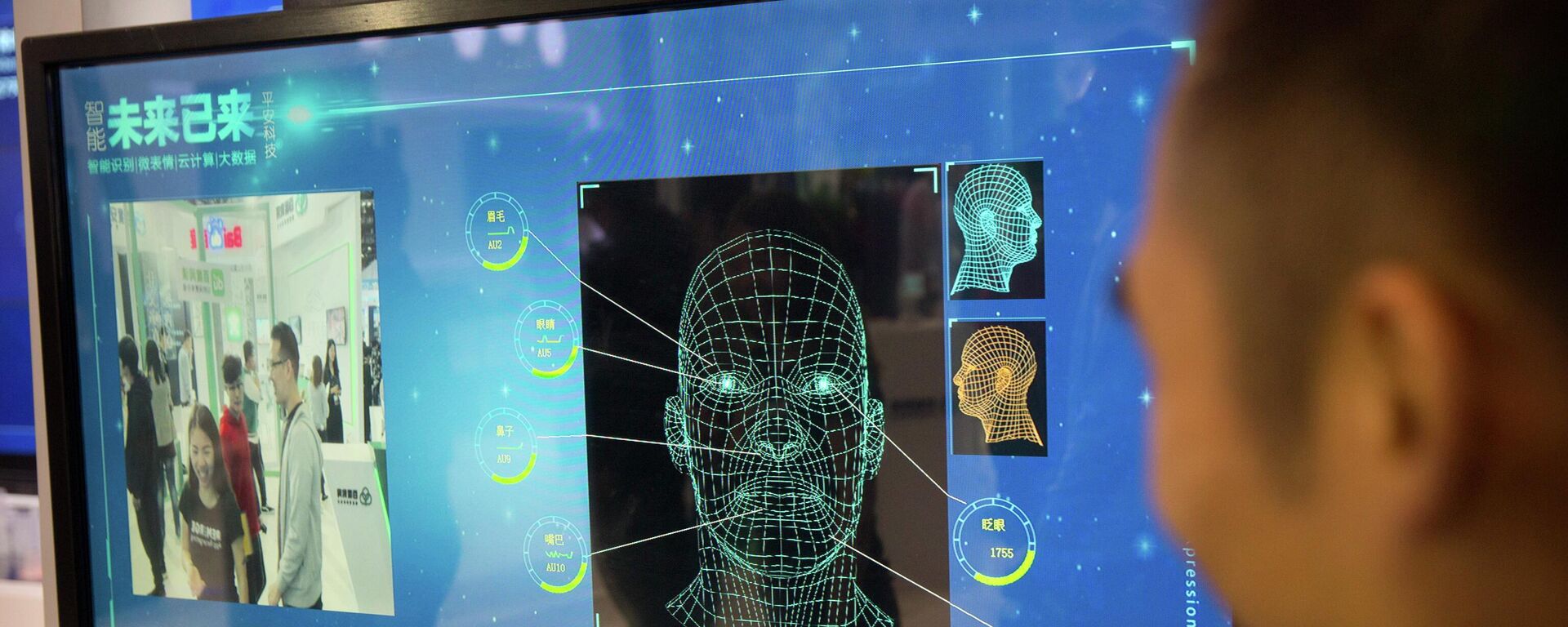 Homem observa um monitor de câmera de reconhecimento facial em um estande da empresa chinesa Ping'an Technology, em Pequim, 25 de abril de 2018. - Sputnik Brasil, 1920, 26.04.2022