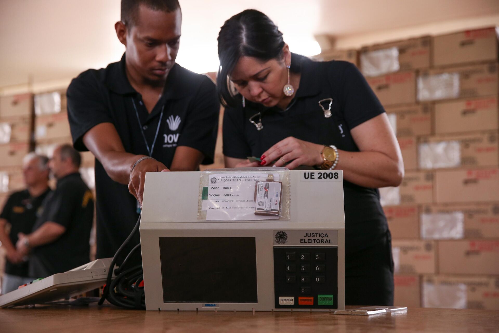 Funcionários do Tribunal Regional Eleitoral do Distrito Federal (TRE-DF) realizam teste de lacração das urnas eletrônicas enviadas para votação no exterior, em Brasília, 19 de setembro de 2018 - Sputnik Brasil, 1920, 13.08.2022