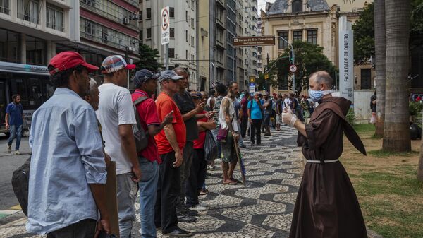 Pessoas em situação de rua fazem fila por quentinhas distribuídas por franciscanos no Largo São Francisco, em São Paulo, em 2 de abril de 2020 - Sputnik Brasil