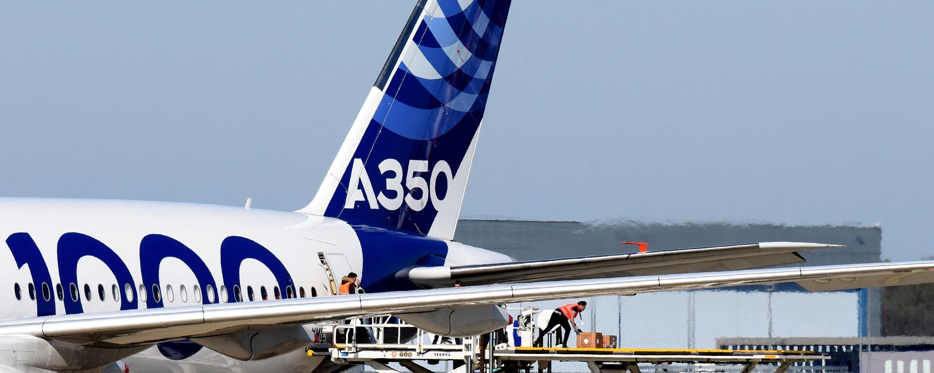 Trabalhadores descarregam carga de um avião Airbus A350-1000 que transporta máscaras faciais da China para a Europa, no Aeroporto de Toulouse-Blagnac em Blagnac, sul da França, onde está localizada a sede da Airbus, em 5 de abril de 2020 - Sputnik Brasil, 1920, 03.05.2022