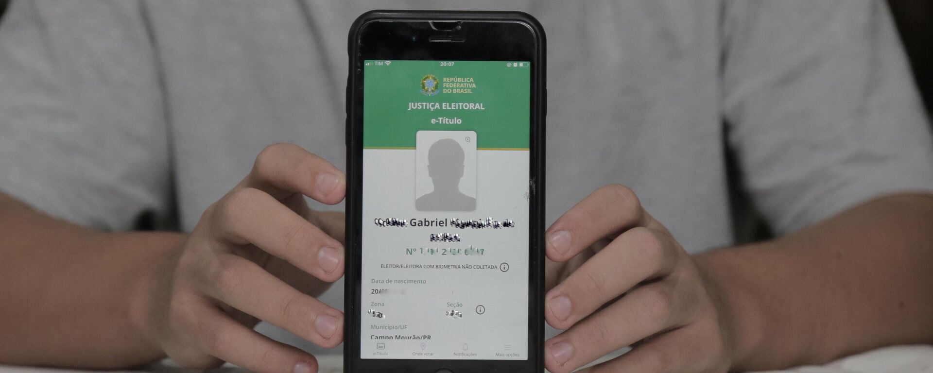 Adolescente mostra o título de eleitor na tela do celular. - Sputnik Brasil, 1920, 04.05.2022