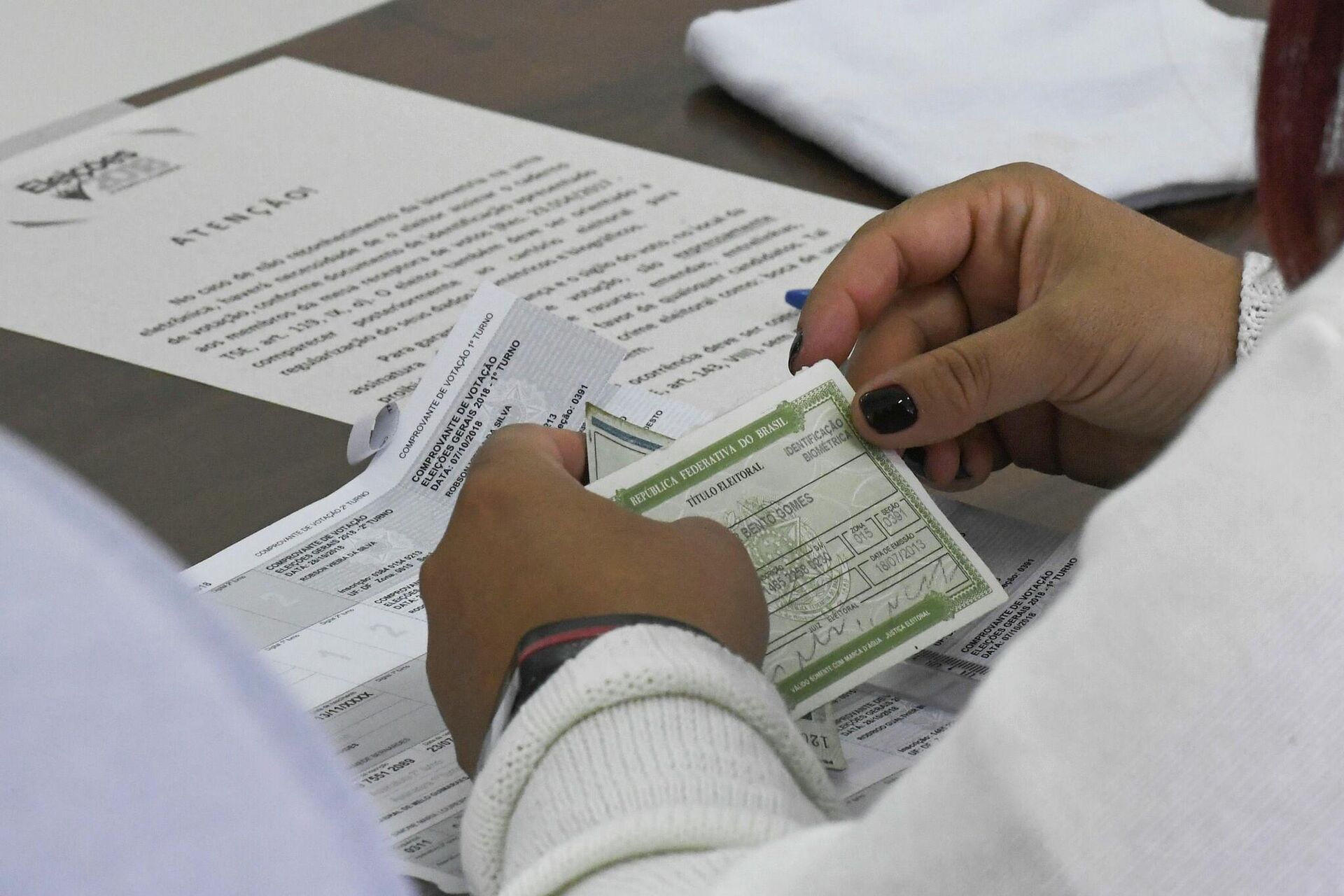 Mesária verifica título de eleitor no Distrito Federal, em 7 de outubro de 2018.  - Sputnik Brasil, 1920, 04.05.2022