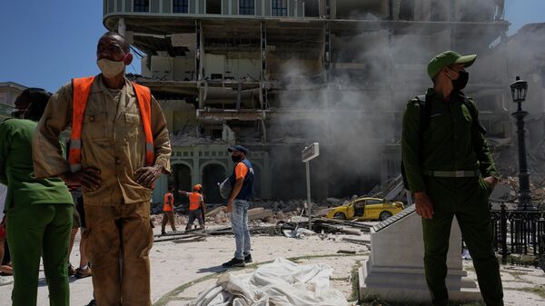 Um corpo coberto com panos é visto ao lado de fora do hotel Saratoga, após uma explosão no estabelecimento, em Havana, Cuba, 6 de maio de 2022. - Sputnik Brasil