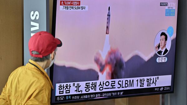 Homem observa noticiário sobre lançamento de míssil balístico da Coreia do Norte, em estação ferroviária de Seul, na Coreia do Sul, em 7 de maio de 2022 (foto de arquivo) - Sputnik Brasil